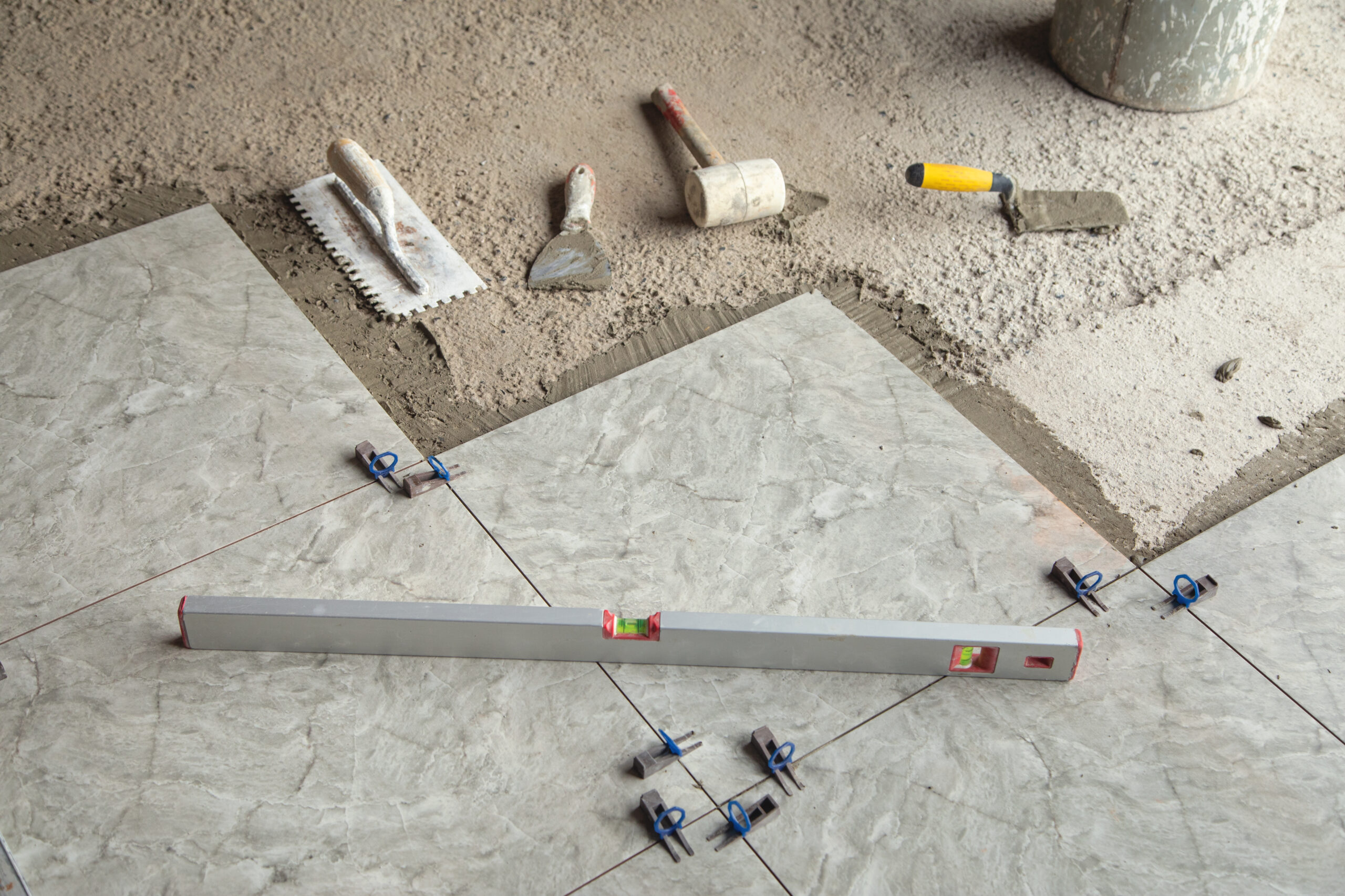 Laying floor ceramic tile. Tools for renovating floor
